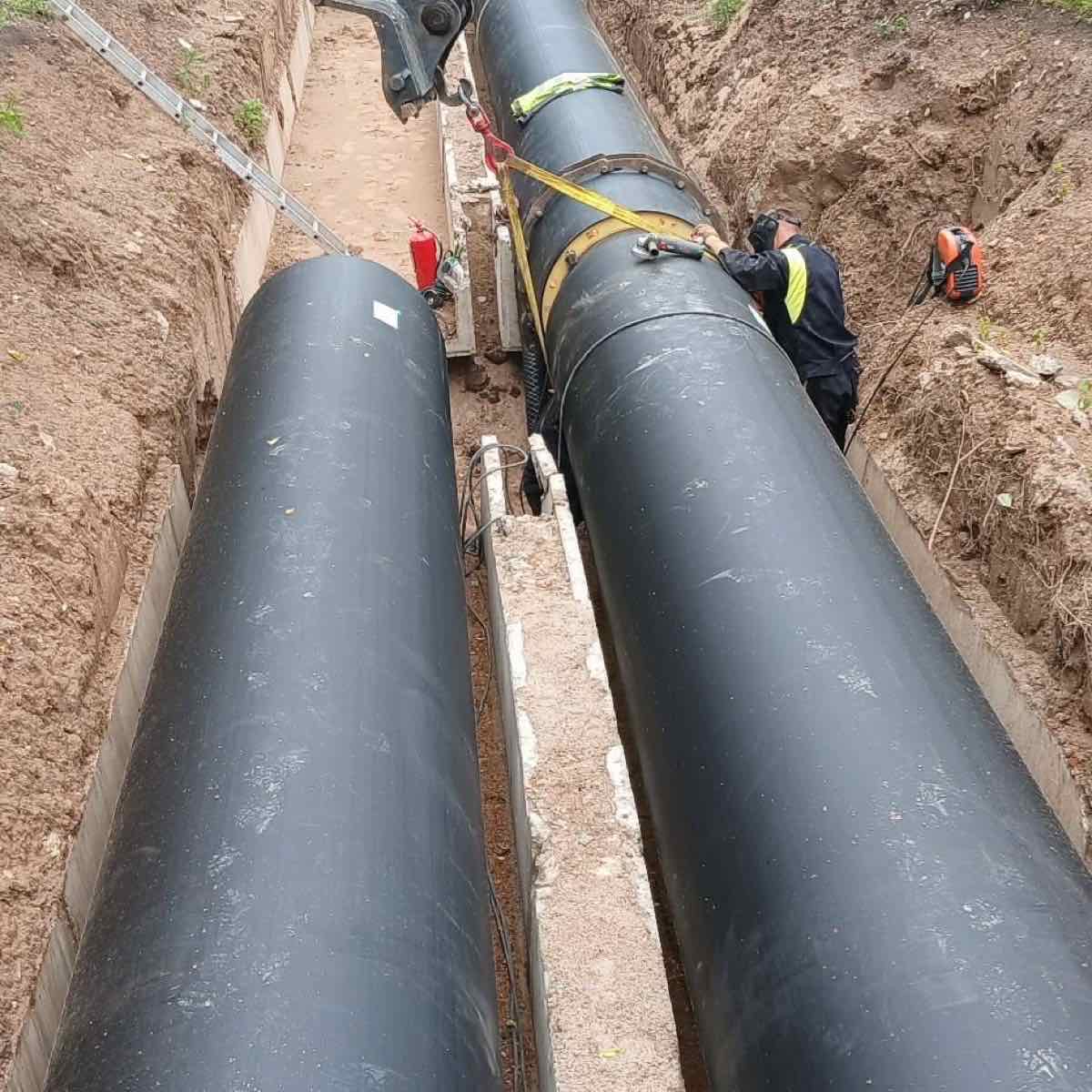 Ilga tranšėja su dviem didelio skersmens izoliuotais šilumos tinklų vamzdžiais